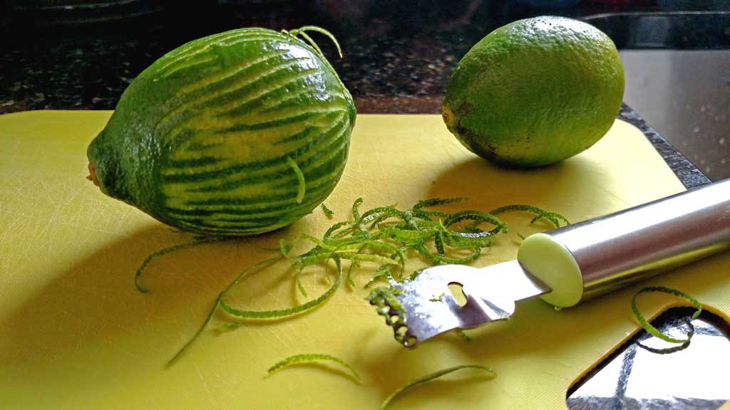 zested limes on cutting board with zester