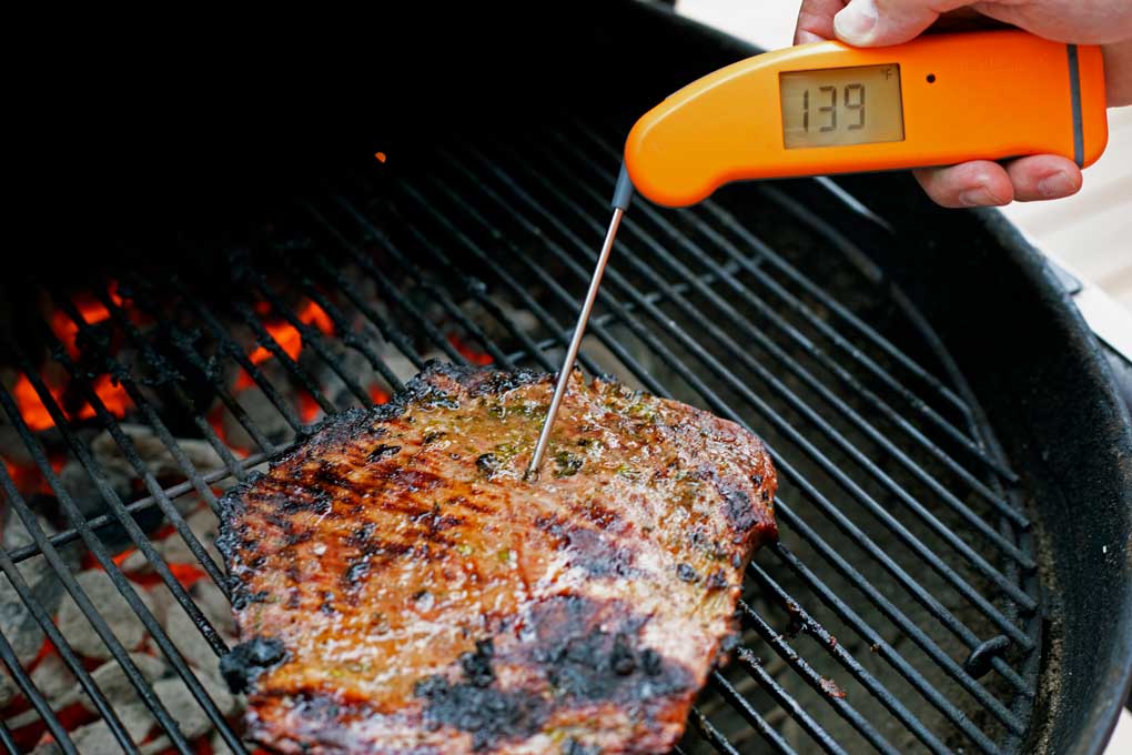 checking temperature of steak with instant-read thermometer