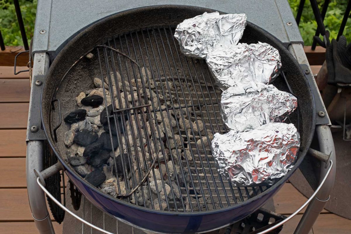 foil-wrapped cabbage on grill with indirect heat