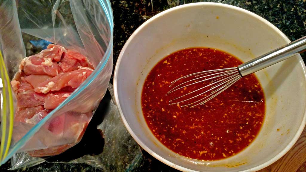 chicken thighs in bag with bowl of marinade
