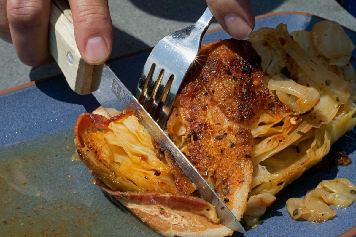 cutting grilled cabbage with fork and knife