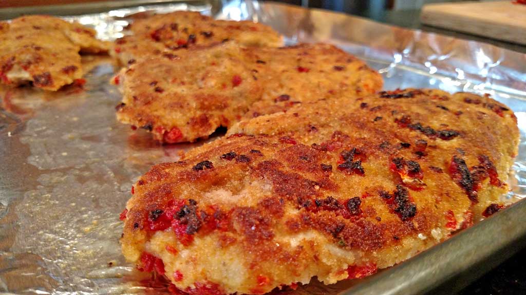 Sun-Dried Tomato Crusted Chicken is a delight! The breast are lightly battered in a sun-dried tomato crust, topped with a rich and tangy sunny butter sauce. | TheMountainKitchen.com