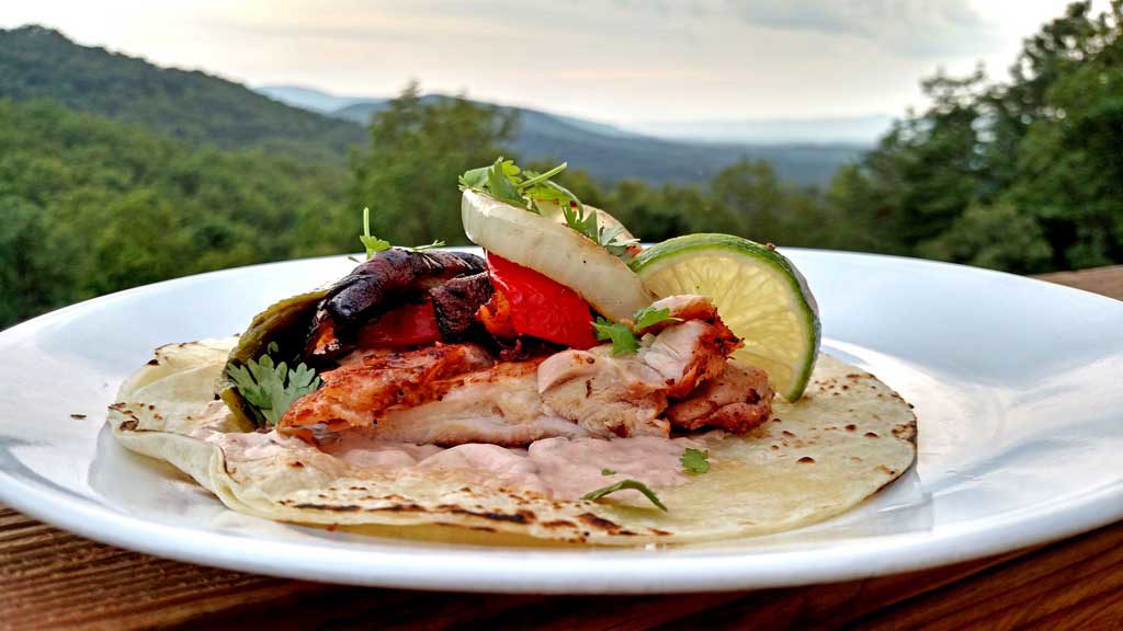 These delicious grilled chicken fajitas are a breeze to make with grilled chicken thighs with Mexican spices served with grilled vegetables on a tortilla. | TheMountainKitchen.com