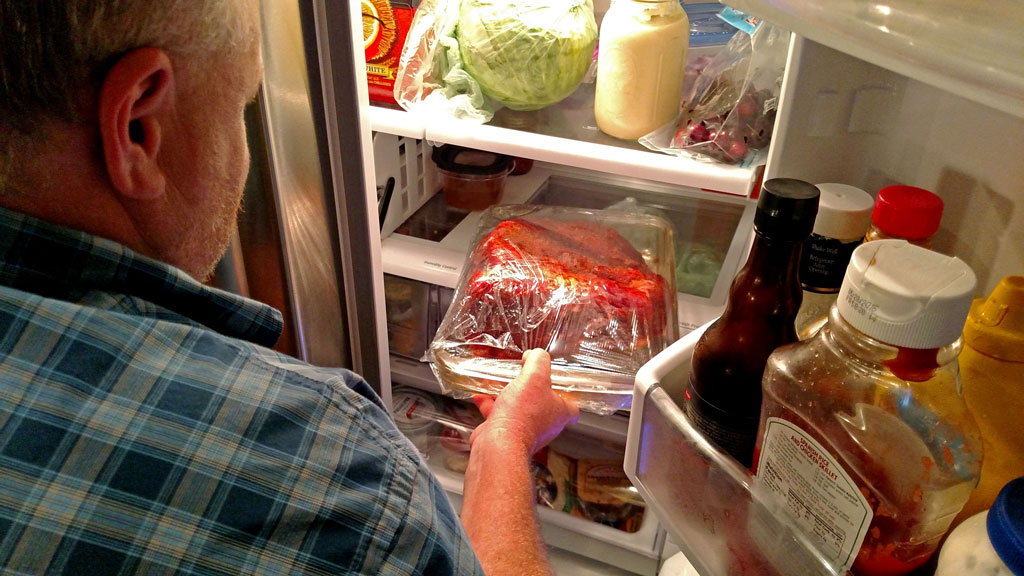 David putting pork in refrigerator