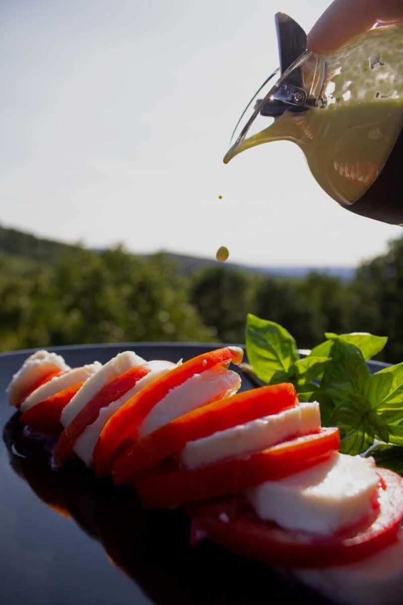 drizzling vinaigrette over caprese salad