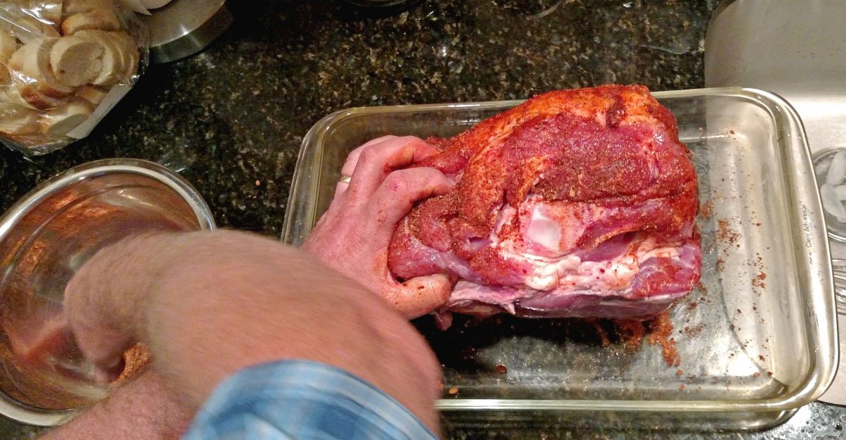 putting rub on pork butt