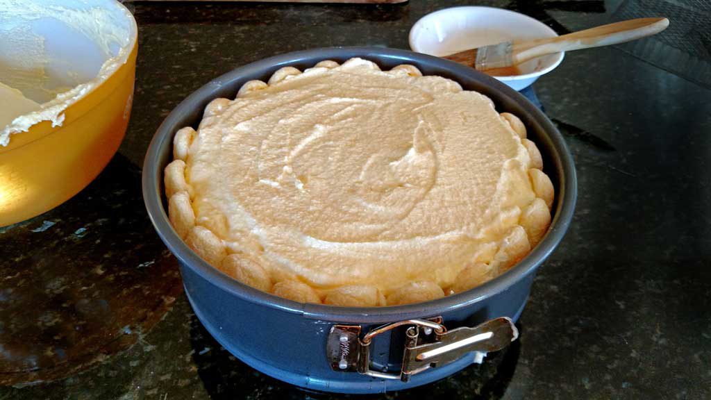 topping homemade tiramisu with cream mixture