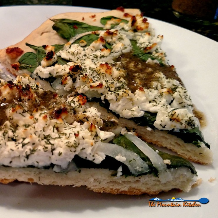 Slices of spinach feta pizza ready to eat