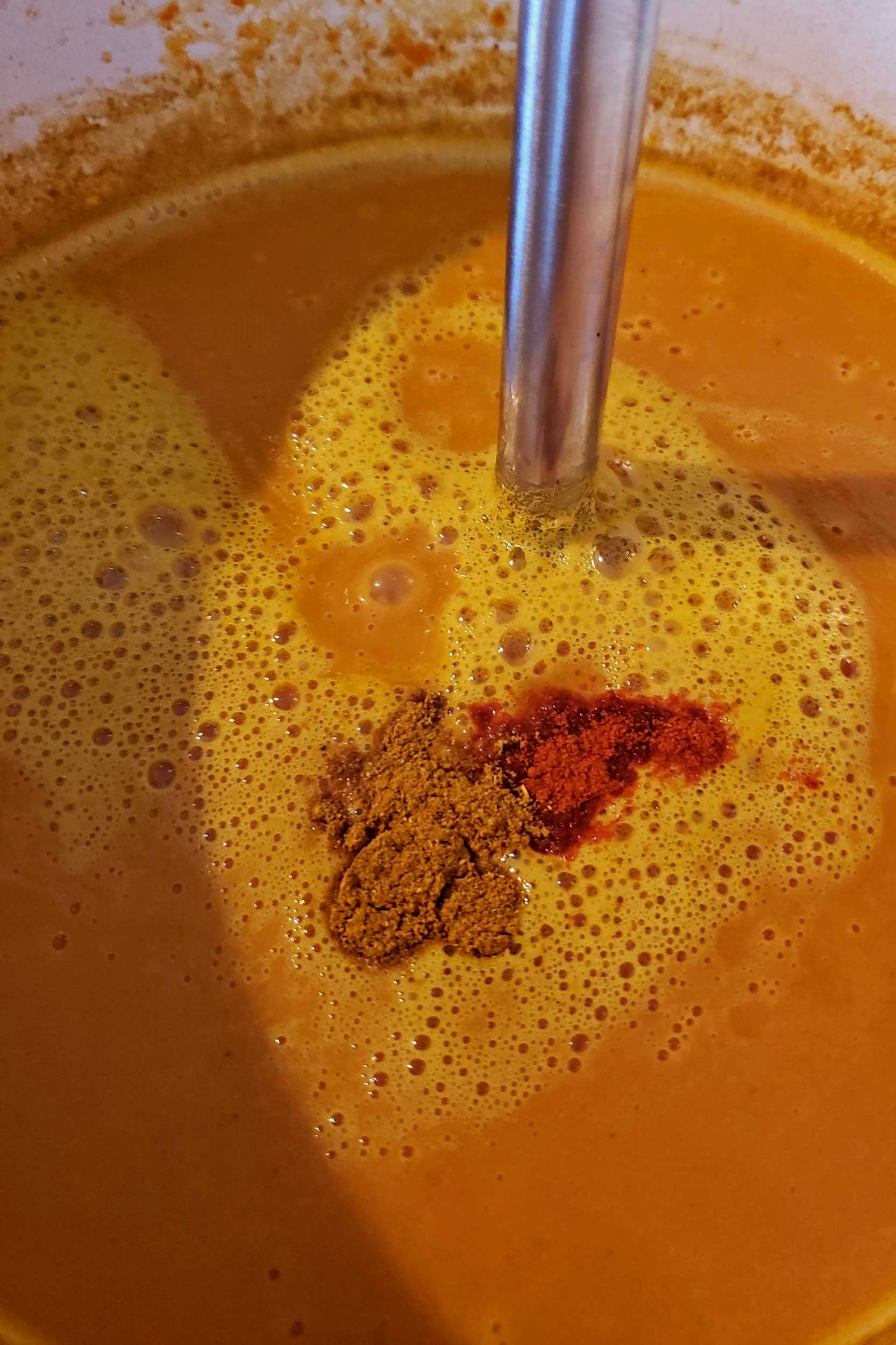 adding spices to the soup