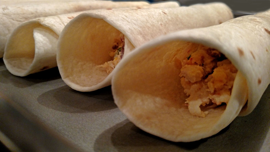 jalapeno popper chicken taquitos on baking sheet ready to bake