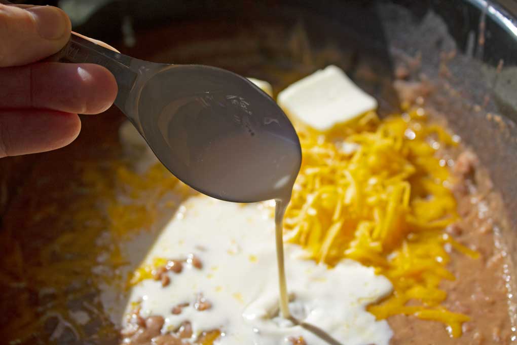 adding milk to crock-pot bean mixture