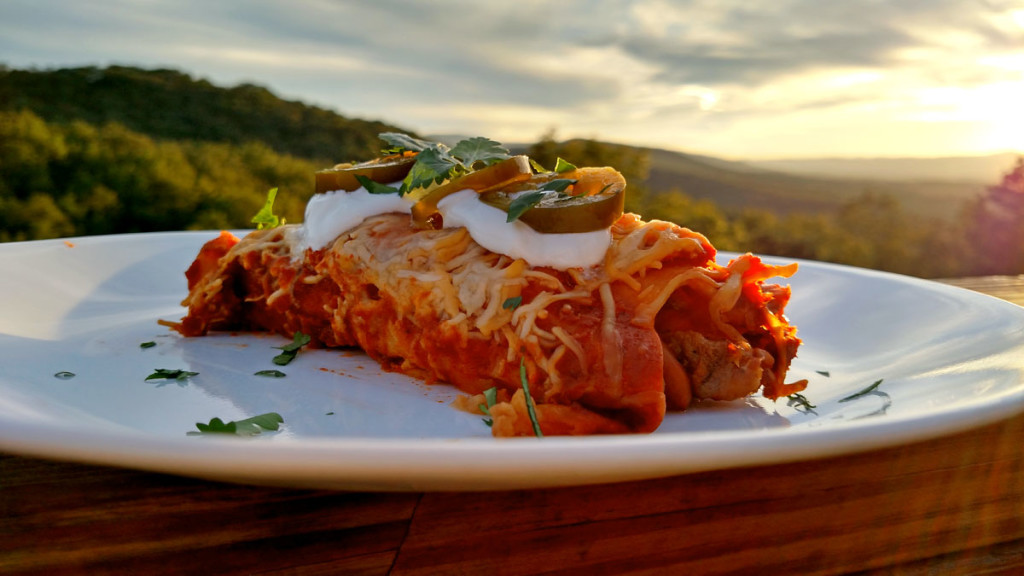 Steak and Refried Bean Enchilada on plate with mountain view
