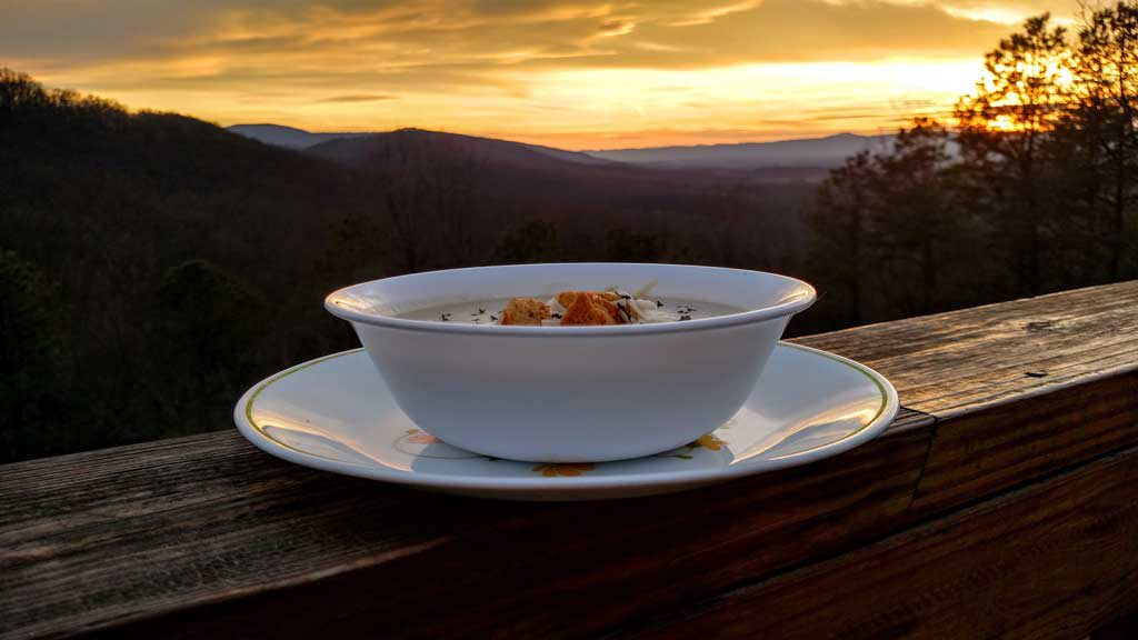 bowl of crock-pot potato leek soup with mountain view