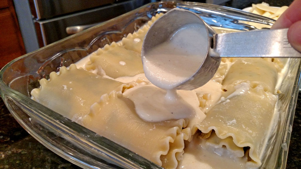 pouring cheese sauce onto noodles