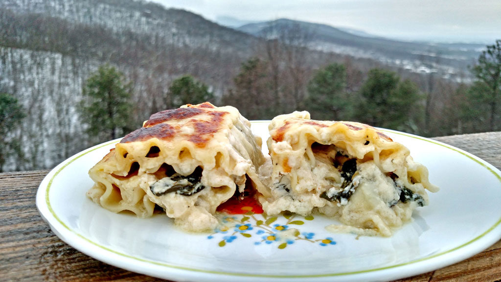 Spinach Artichoke and Mushroom Rollatini on plate with mountain view