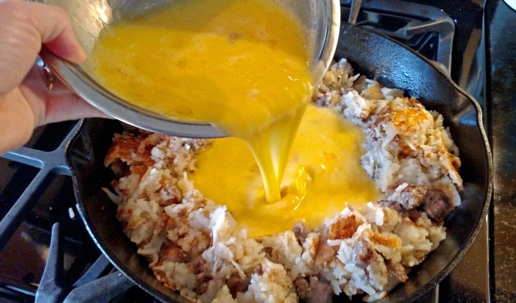 pouring the eggs into the camper's breakfast hash