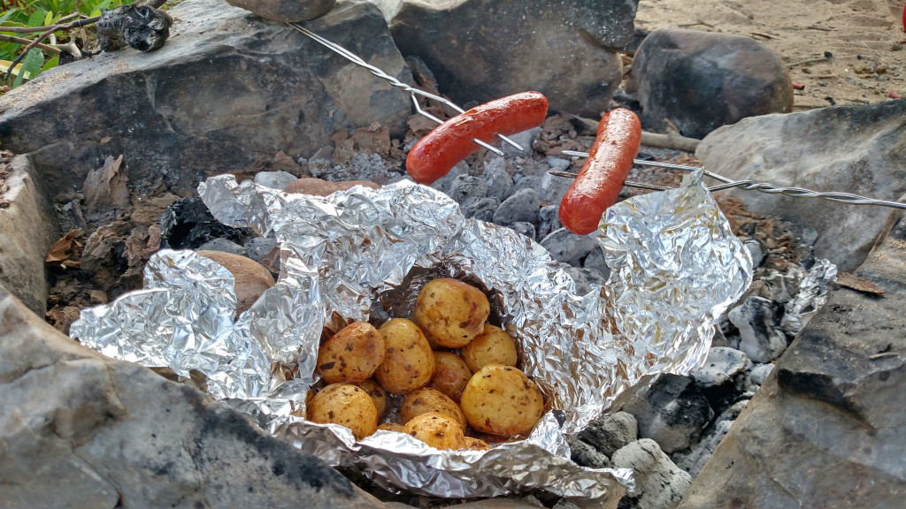 hot dogs and potatoes over camp fire