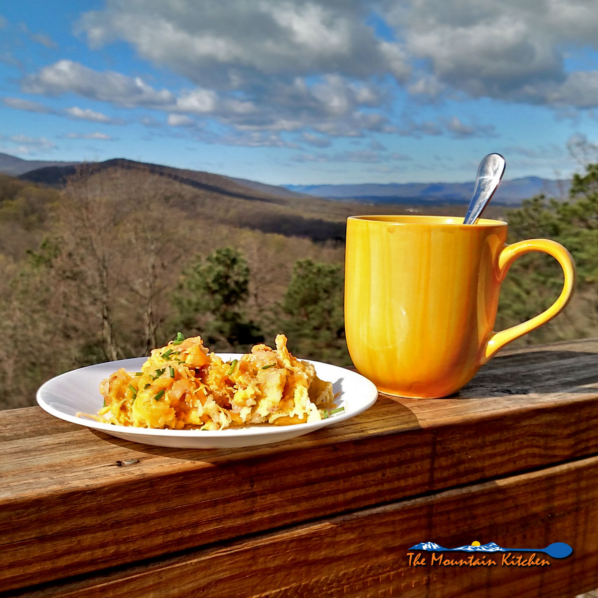 Camper’s Breakfast Hash on a plate with cup of coffee and mountain view