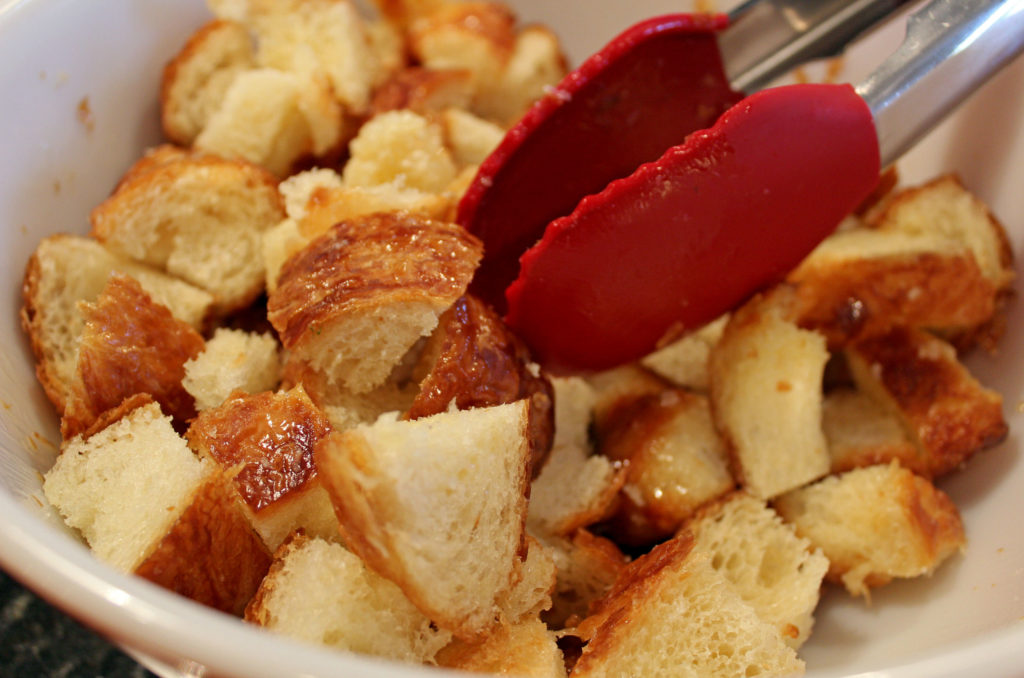 bread cubes in a bowl with tongs