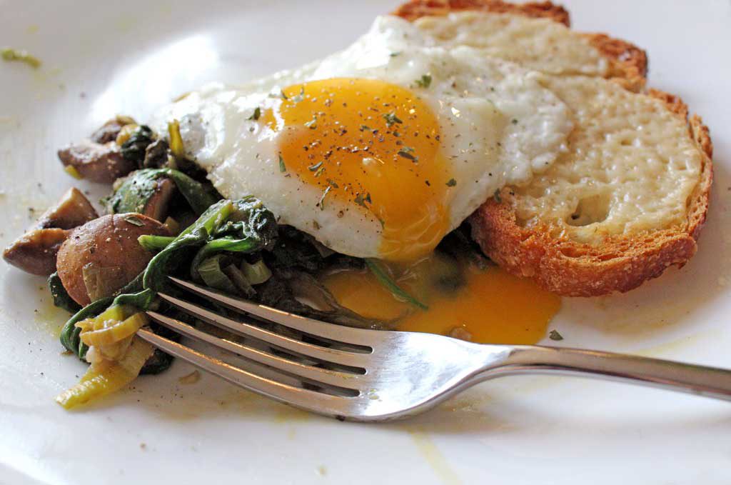 leeks mushrooms with toast and fried eggs with broken yolk