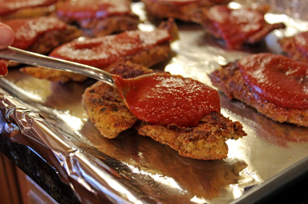 spoon smearing sauce on chicken
