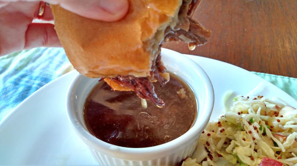dipping sandwich into au jus