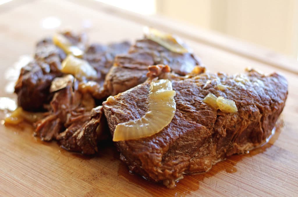 cooked chuck roast resting on cutting board