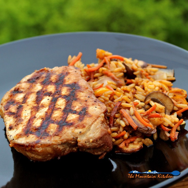 Grilled teriyaki pork chop on plate with rice and vegetables