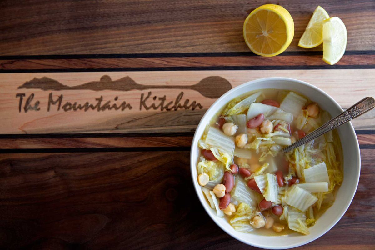 bowl of Napa cabbage and bean soup with lemon slices