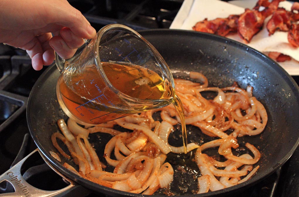 Pouring vinegar into skillet with onions