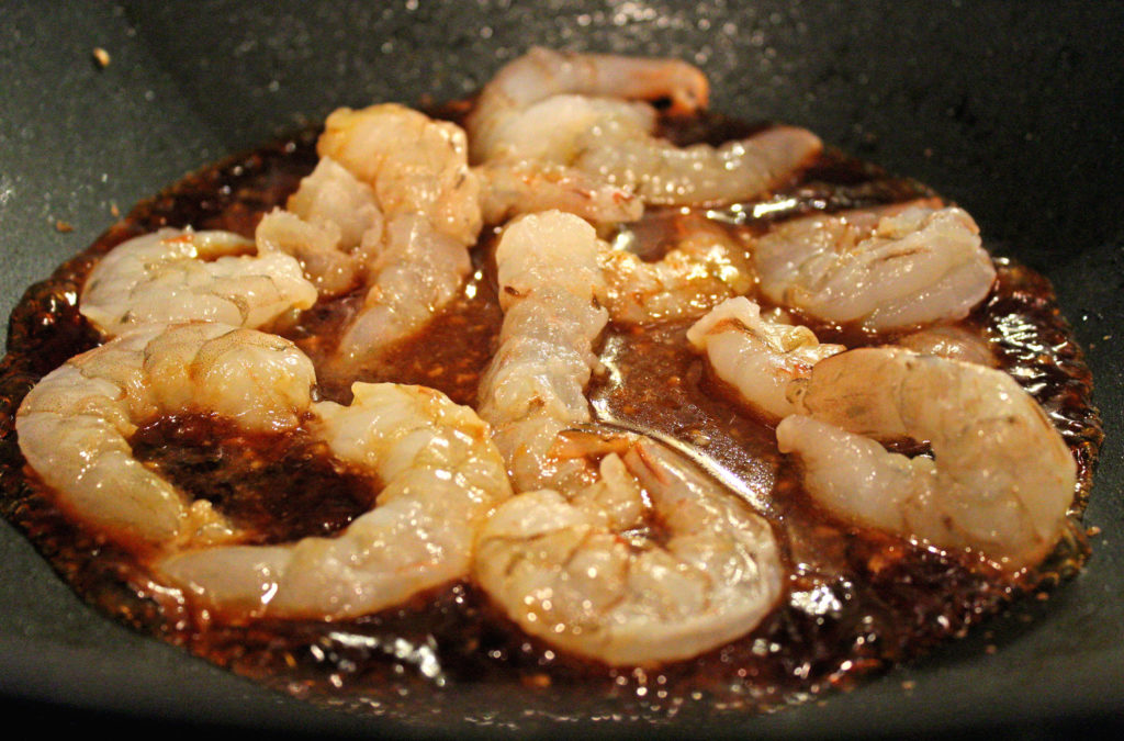 shrimp cooking in a wok with sauce