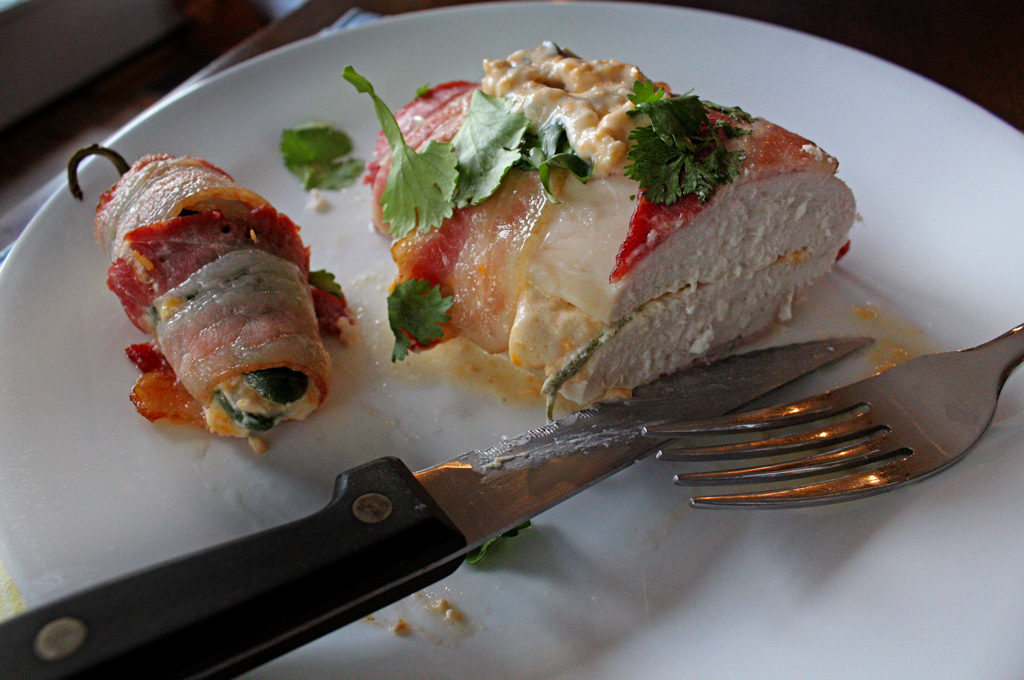 bacon wrapped jalapeno popper chicken breasts cut with knife