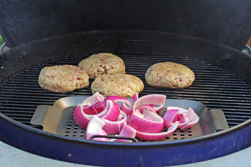 pork burgers and onions on grill