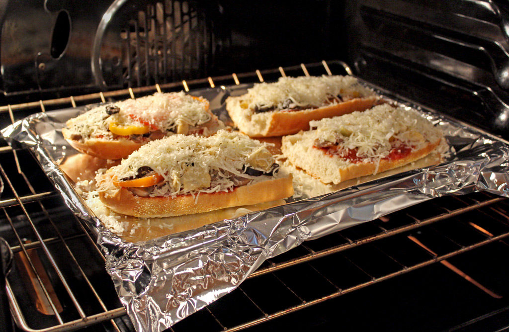 Vegetable French bread pizzas baking in oven