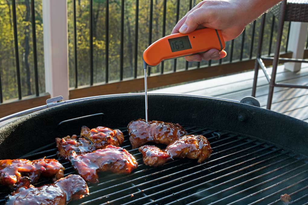 checking temperature of chicken with instant-read thermometer