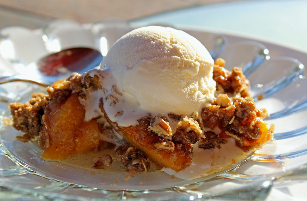 David's cinnamon peach crisp is made with fresh peaches topped with crunchy rolled oats, brown sugar, pecans, and butter with warm spices. It's delicious! | TheMountainKitchen.com