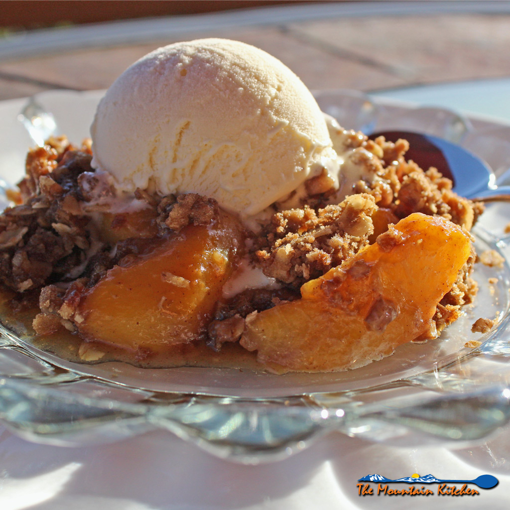 David's cinnamon peach crisp is made with fresh peaches topped with crunchy rolled oats, brown sugar, pecans, and butter with warm spices. It's delicious! | TheMountainKitchen.com