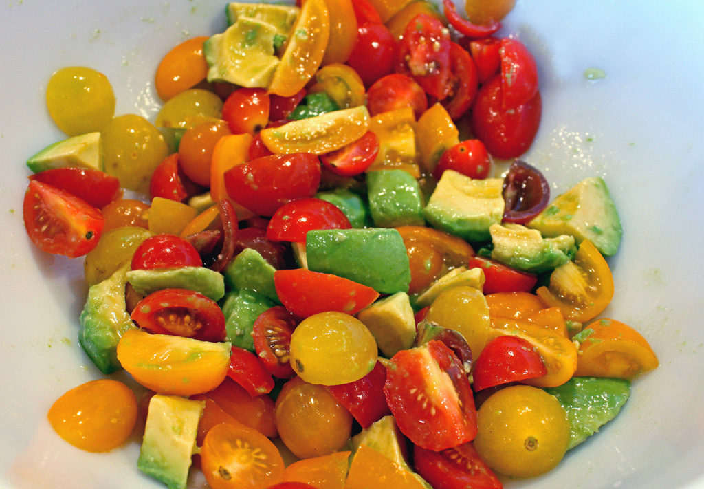 Simple ingredients with tons of flavor, this low calorie Grilled Corn and Black Bean Salad is practically a fiesta in a bowl, loaded with grilled corn, hearty beans, tomatoes, and creamy avocado with a zippy sweet homemade lime dressing that blends the flavors all together perfectly. | TheMountainKitchen.com