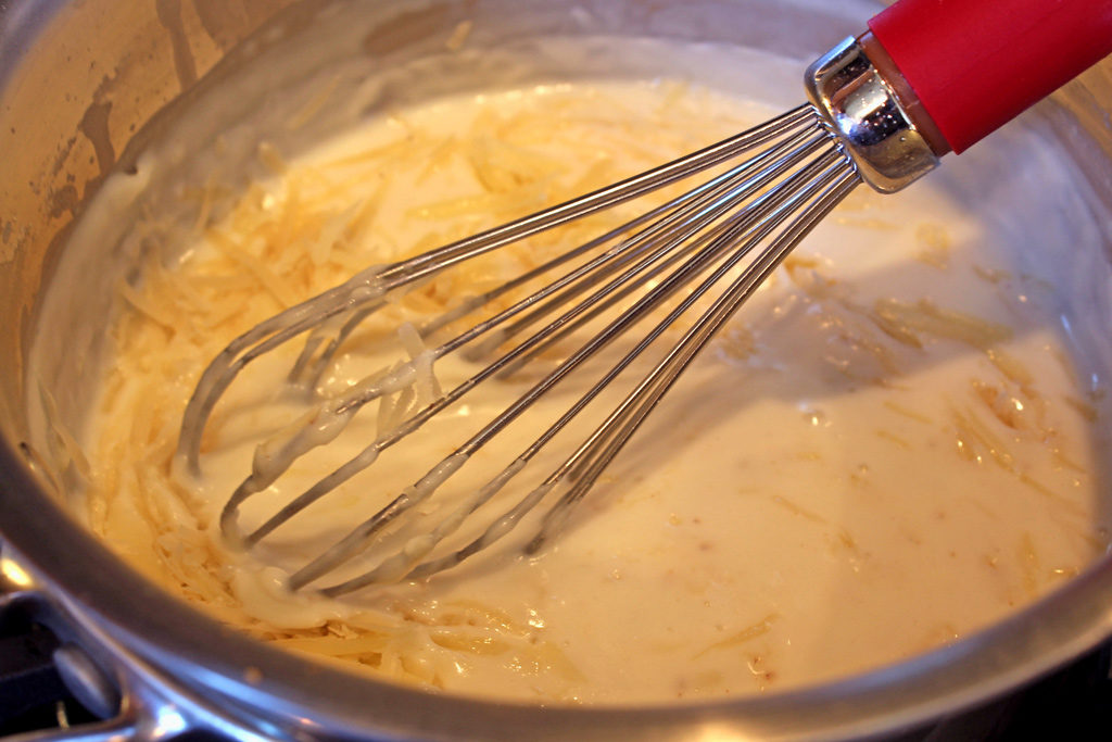 whisking cheese sauce