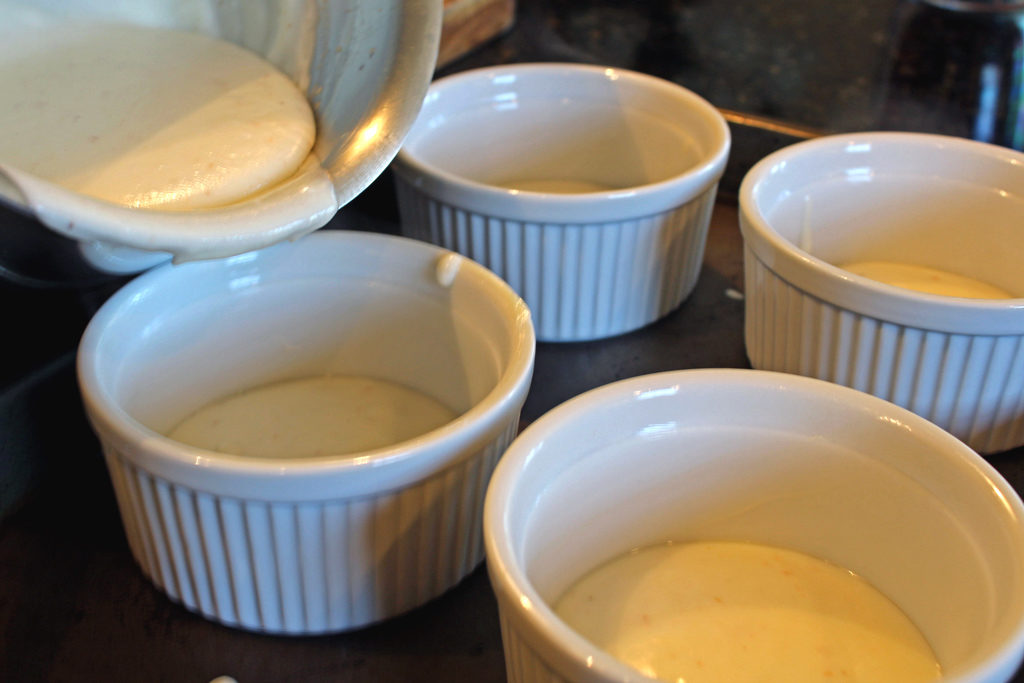 pouring cheese sauce in ramekins