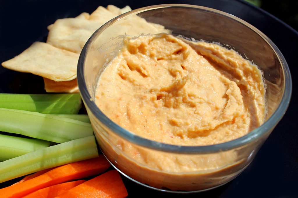 roasted red pepper hummus in bowl with veggies