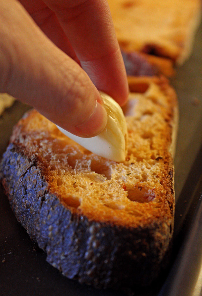 rubbing garlic on toasts