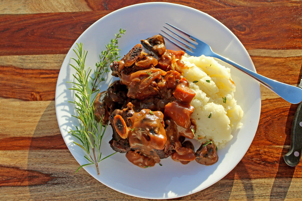 Red Wine Braised Beef Short ribs on plate with mashed potatoes and a fork