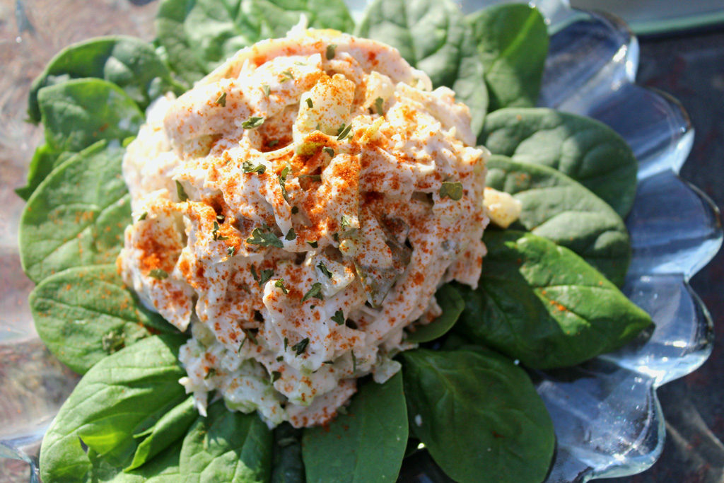 roasted chicken salad on a bed of fresh spinach