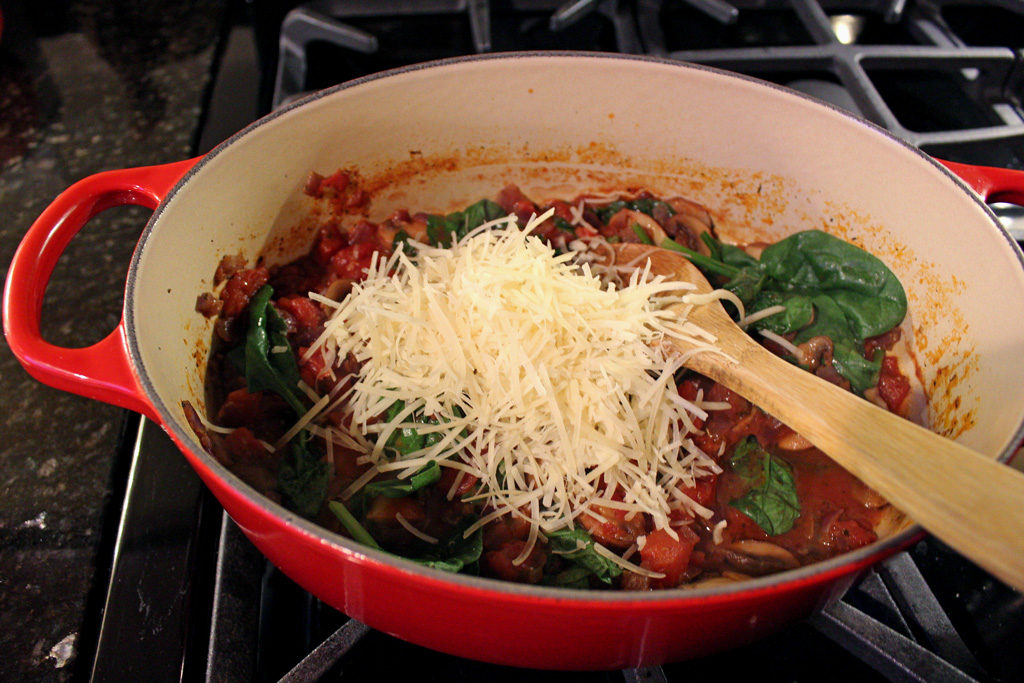 shredded cheese in pot with sauce