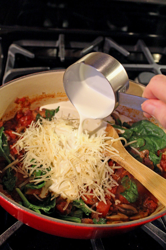 pouring cream into pot of sauce