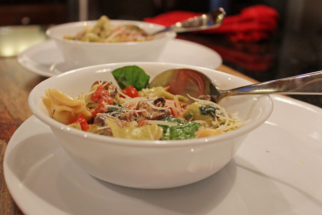 Tortellini With Spinach Tomato Cream Sauce, a decadent creamy tomato sauce surrounds pillowy soft cheese tortellini with tomatoes, onions and fresh spinach. | TheMountainKitchen.com