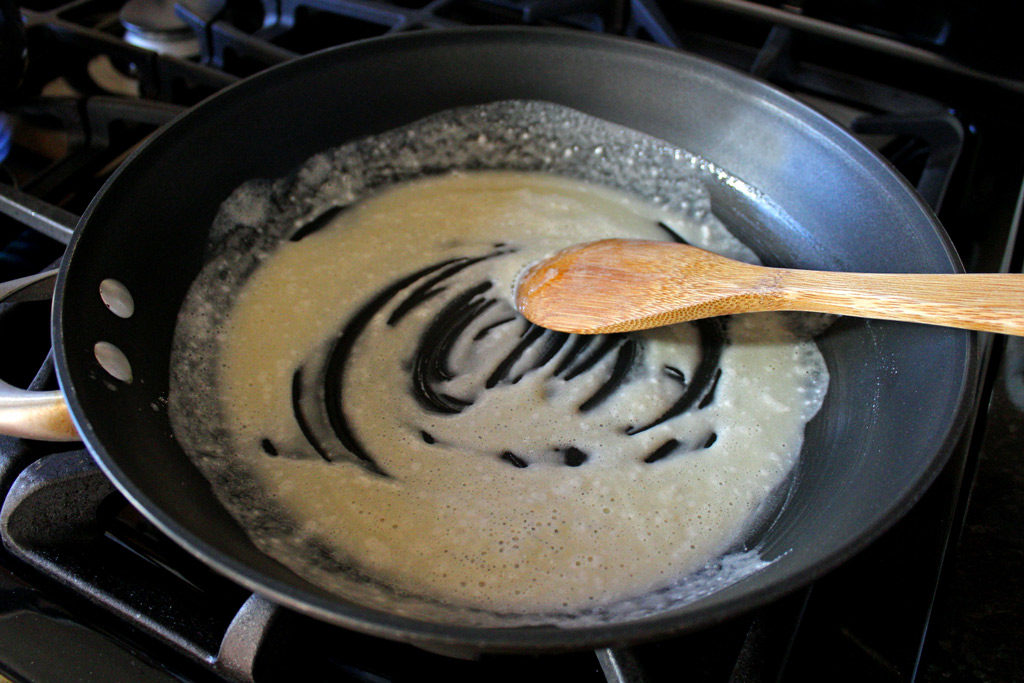 wooden spoon stirring roux in skillet