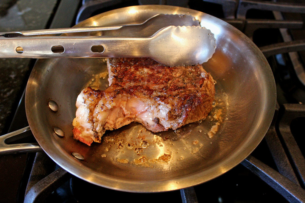 steak frying in pan