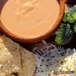 beer horseradish cheese sauce in bowl with broccoli and chips